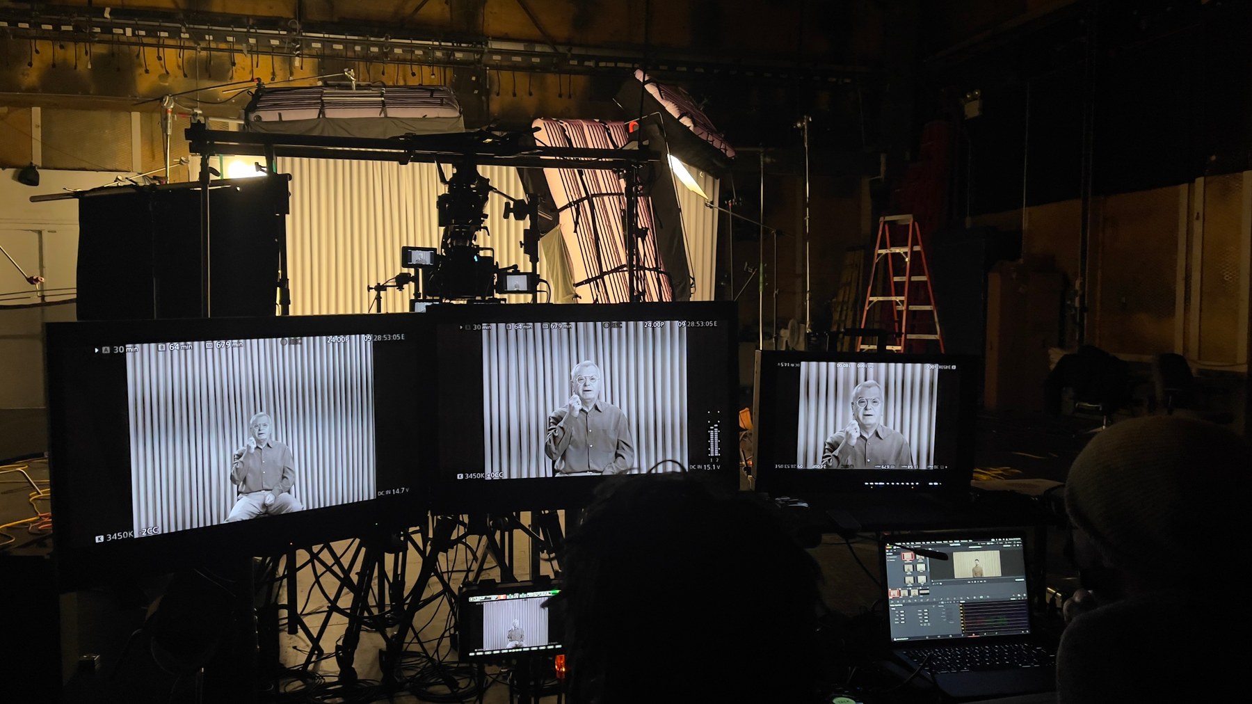 Production monitors framing an interview for The Conversation Machine