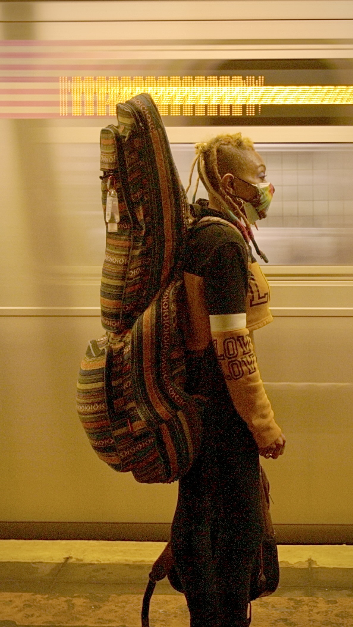 A New Yorker carrying musical instruments on a subway platform